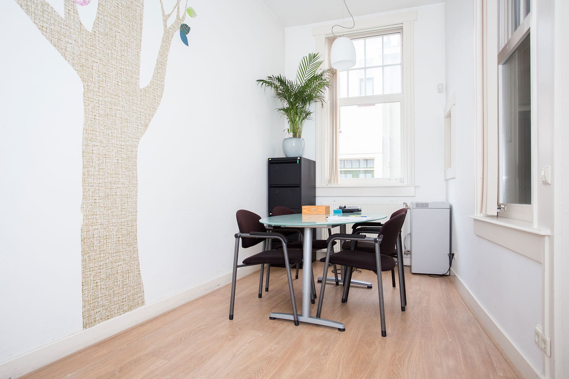 Spreekkamer met overlegtafel en vier stoelen